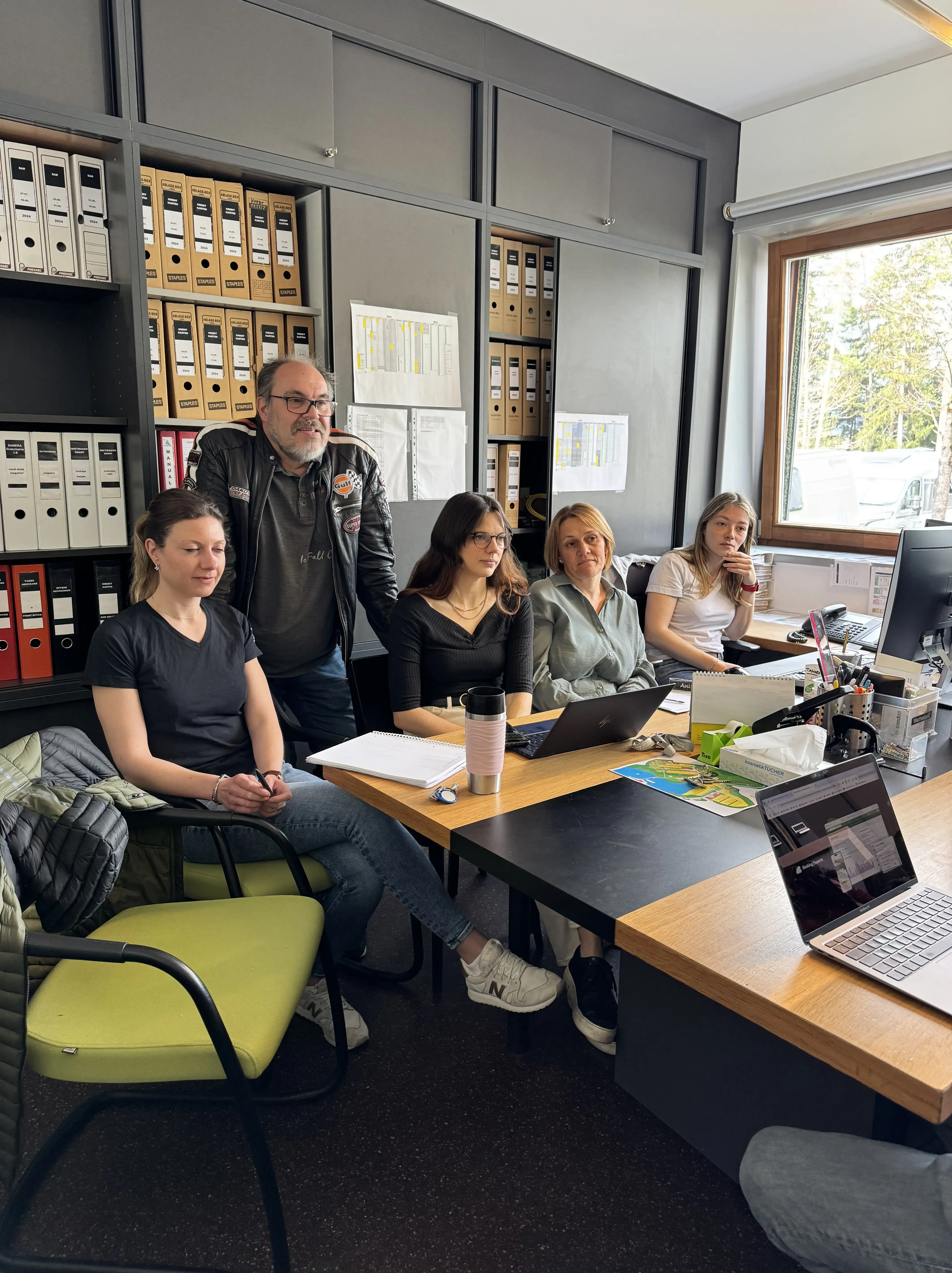 Das Team vom Natterer See rundum Georg Giner sitzt am Schreibtisch und hört aufmerksam einer Schulung zu